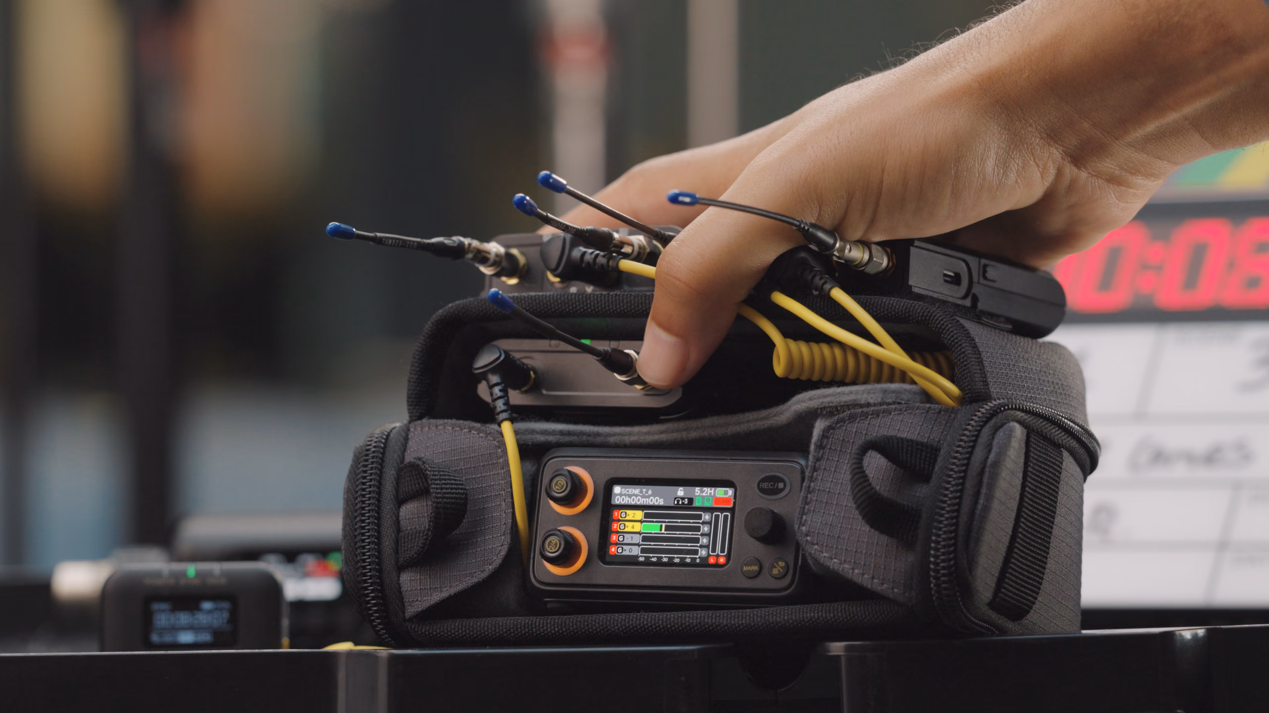 PR-4 in the Field Audio Bag (Mini), wireless receivers cabled in on top, a hand resting on the rig