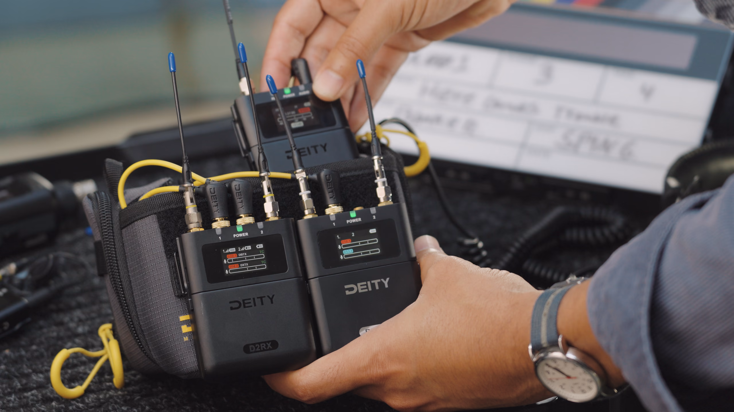 Hands lifting a PR-4 rig out of the Field Audio Bag (Mini) with two Deity wireless receivers mounted on top