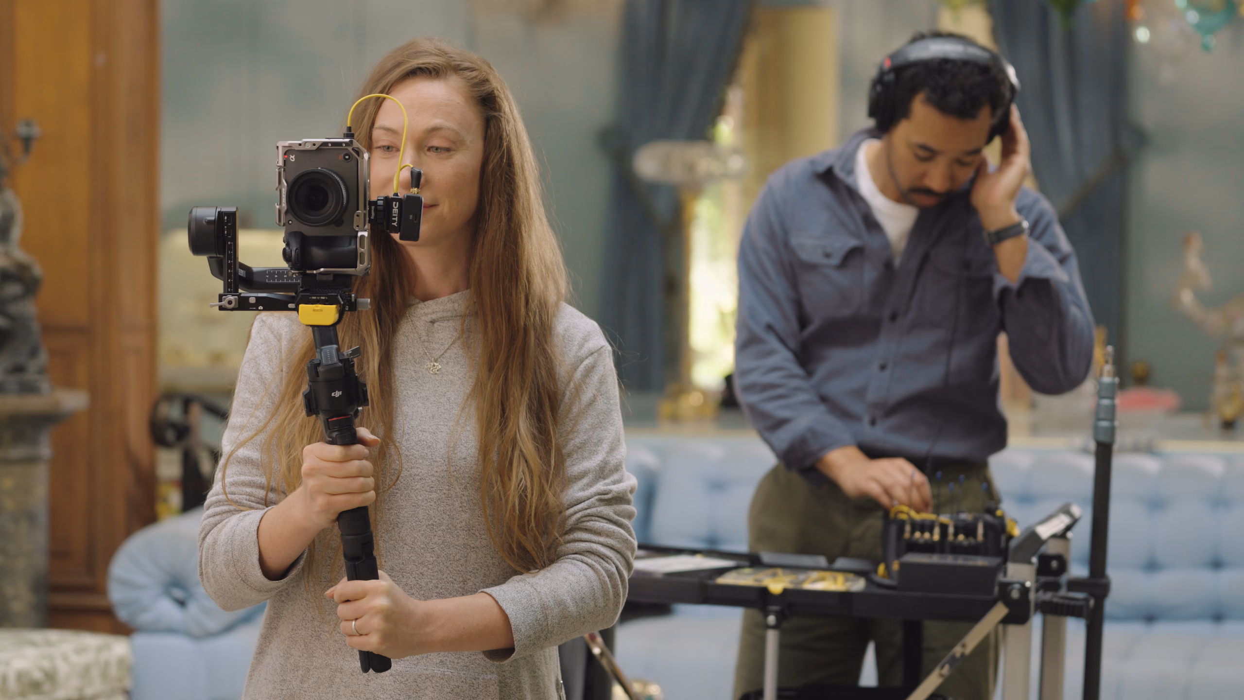 A camera operator on a gimbal and a sound mixer in headphones at a PR-4 on a cart, working the same scene
