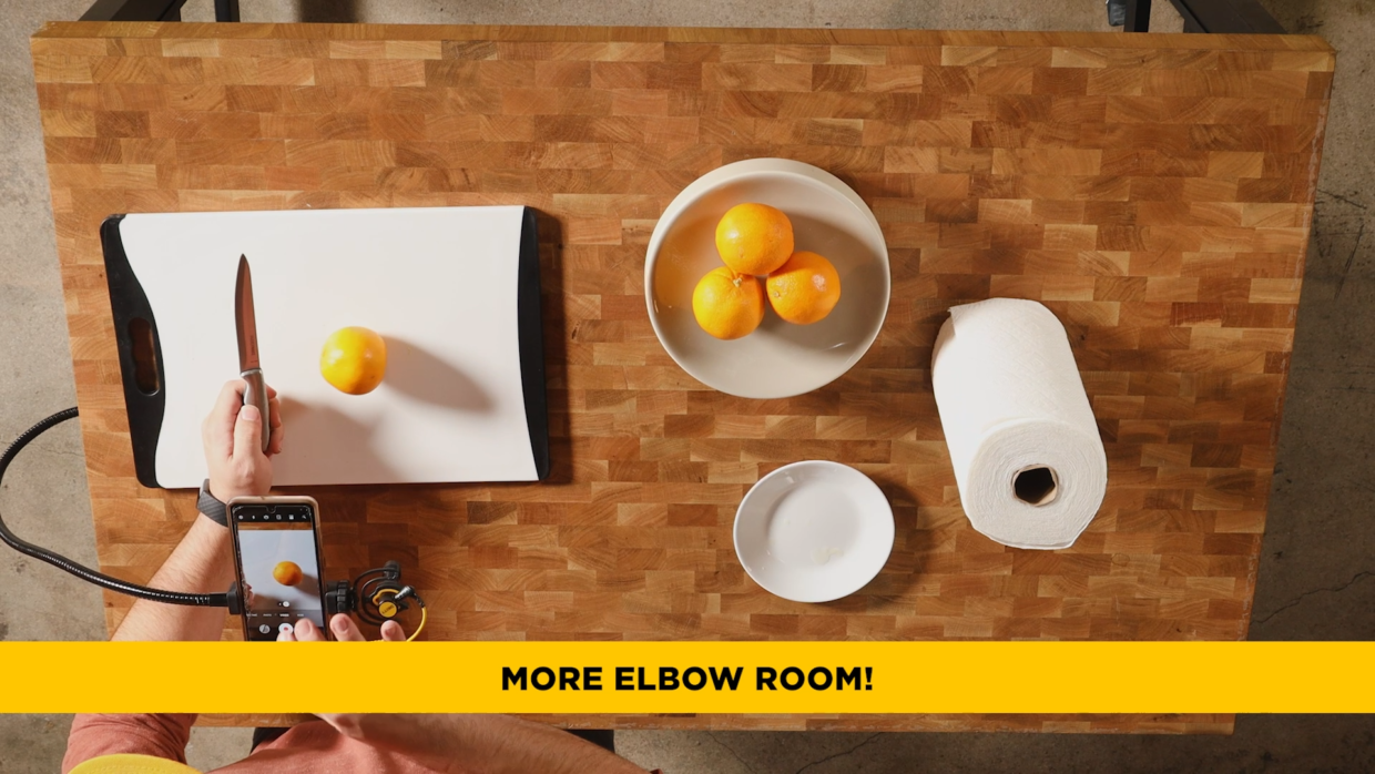 top-down camera of a kitchen set where a man is slicing oranges and filming it. Deity V-Mic D4 Mini