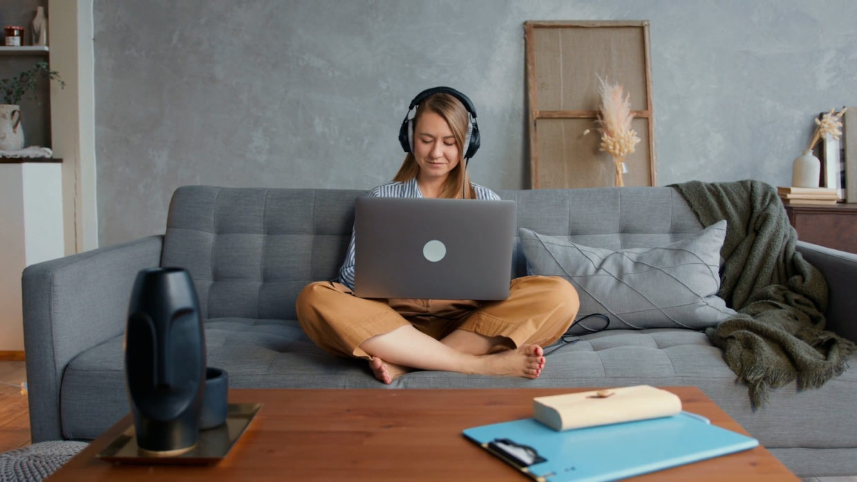 Woman editing podcast on the couch